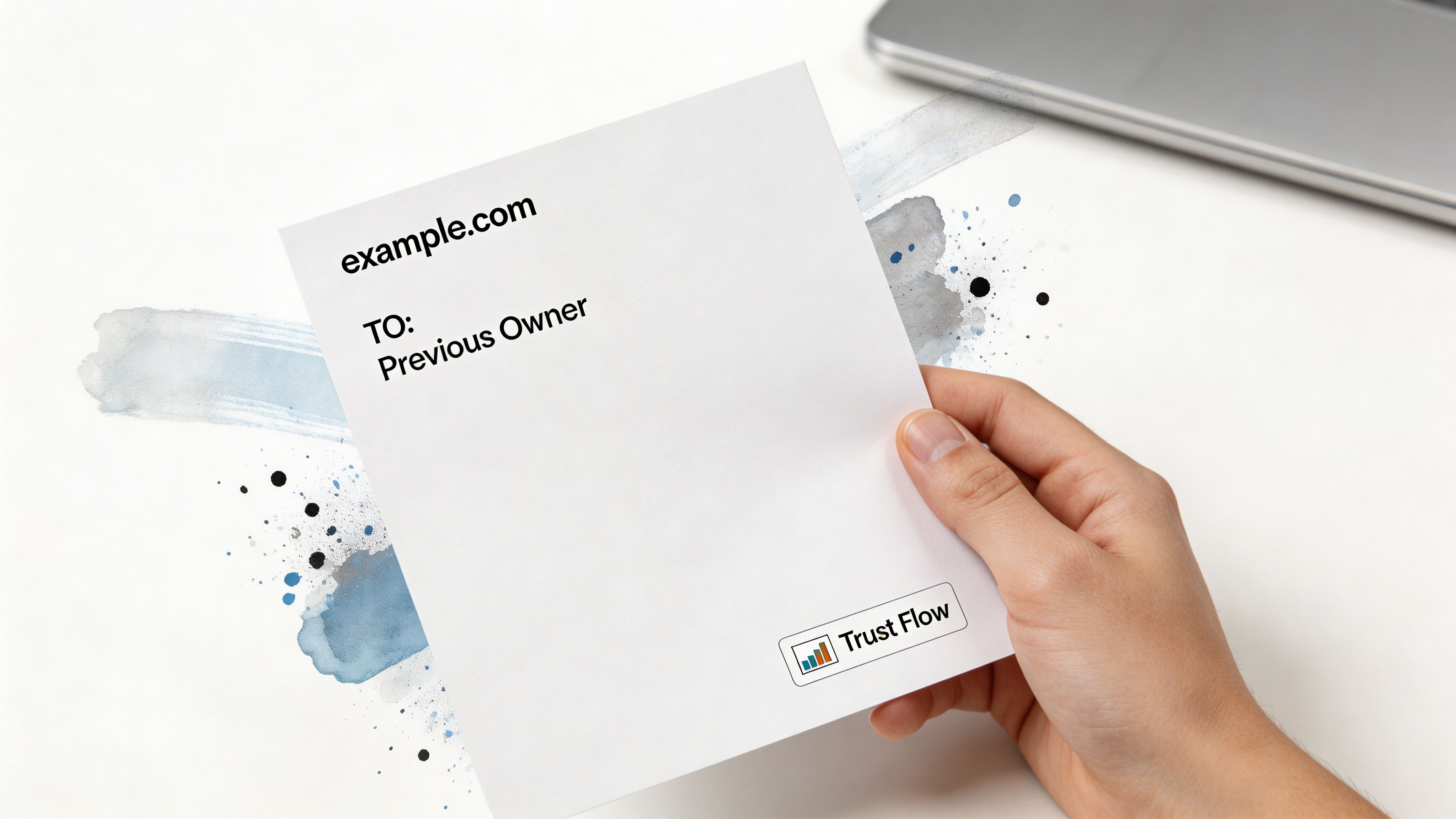 A hand holding a paper that displays the website domain example.com and the text Previous Owner.